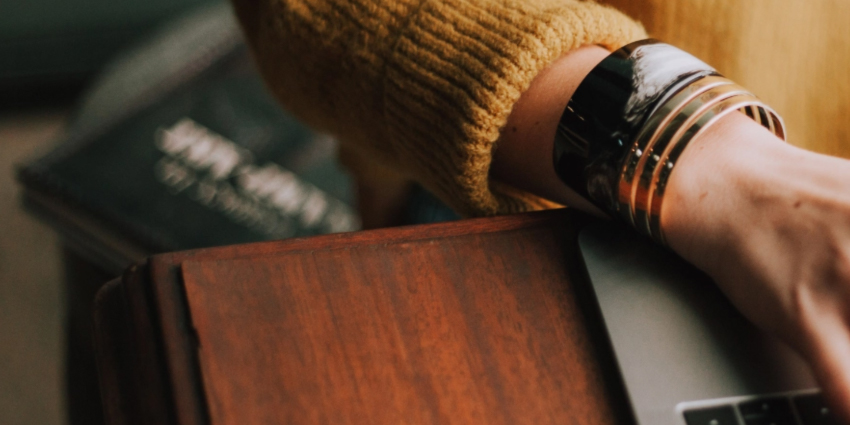 Picture of a person with their hand on a laptop keyboard